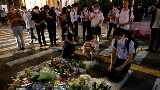 People pay respects at the site where late former Japanese Prime Minister Shinzo Abe was shot