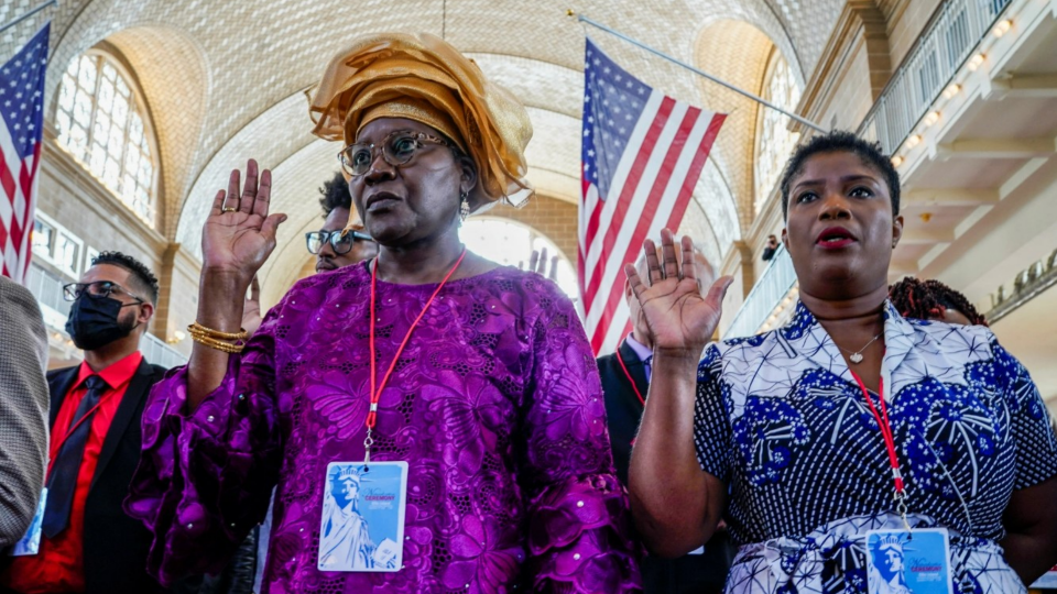 People take oath during a naturalization ceremony at Ellis Island in New York