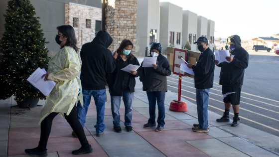 People wait in line at the Dr. Guy Gorman Senior Care Home to receive the Pfizer COVID-19 vaccine on the Navajo Nation in Chinle