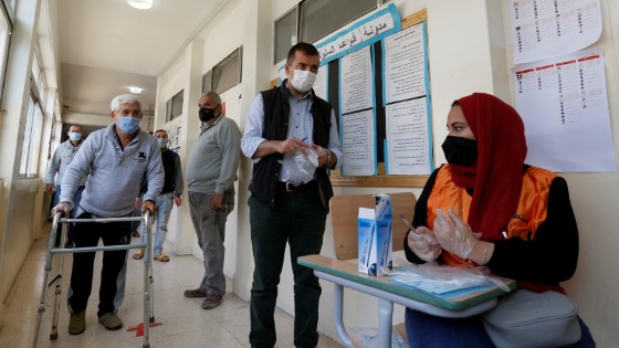 People wait to cast their votes during parliamentary elections