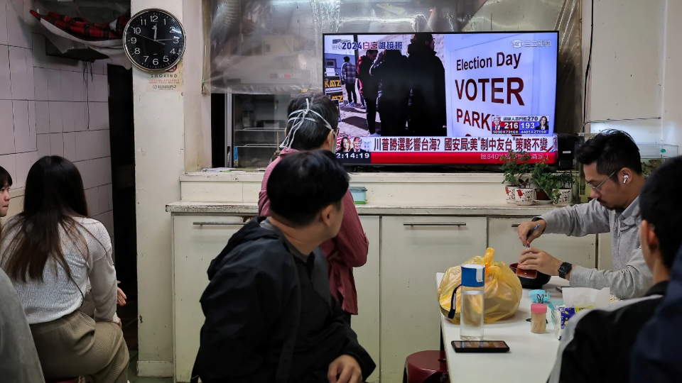 People watch a live news broadcast of the U.S. election at a restaurant in Taipei, Taiwan