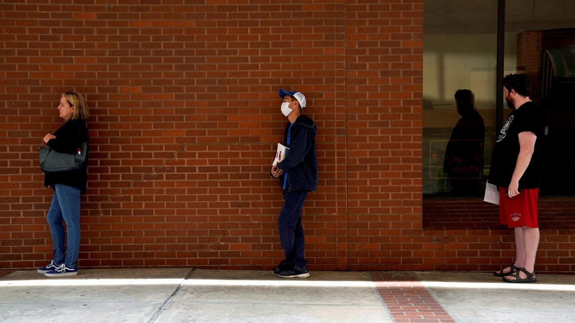 People who lost their jobs wait in line to file for unemployment following an outbreak of the coronavirus disease