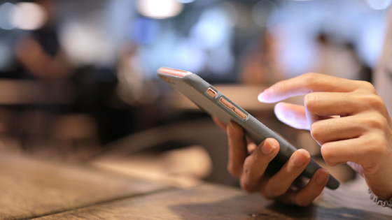 Person scrolling on phone with a protective case on it