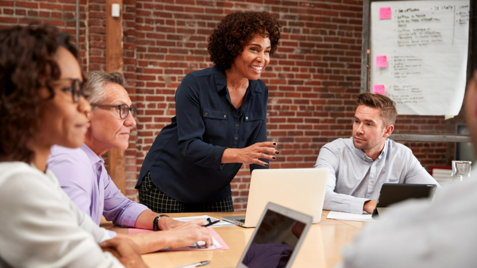 Person speaks while standing up during a business meeting