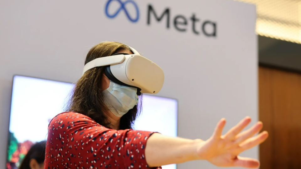 Person using VR headset with Meta logo in the background