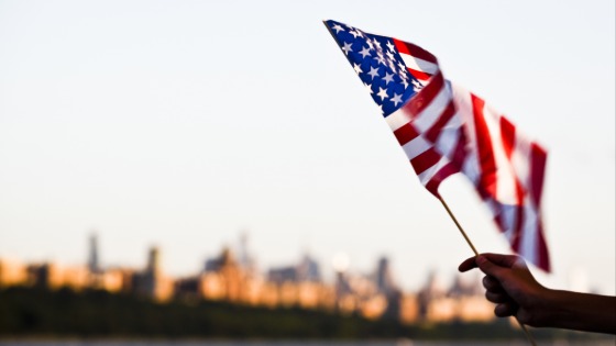 Person waiving American flag at the Hudson River