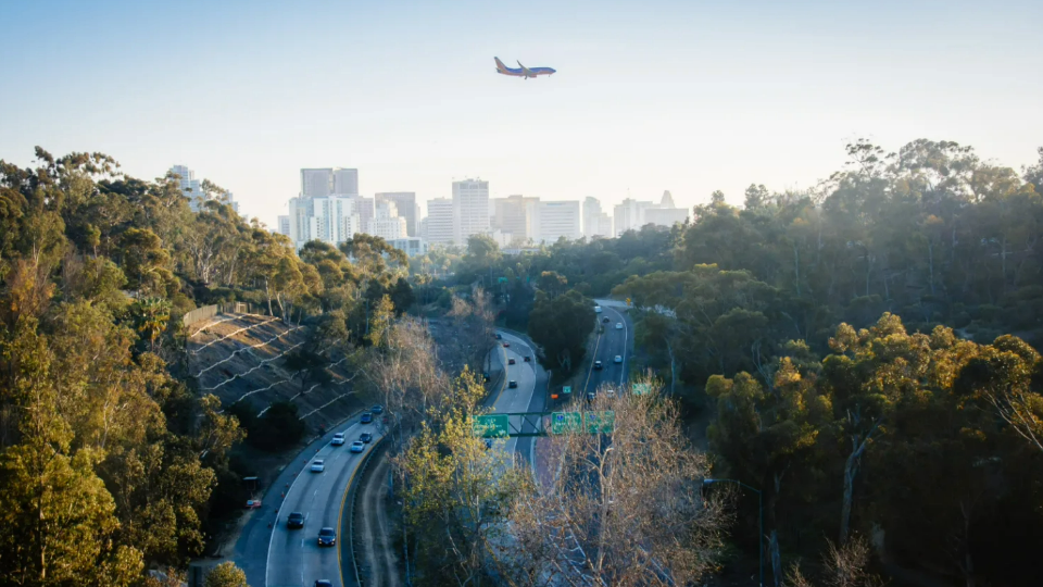 Plane flies over freeways in San Diego, California