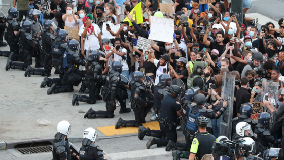 Police and protesters kneeling