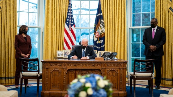 President Joe Biden signs executive action with Vice President Kamala Harris and Secretary of Defense Lloyd Austin