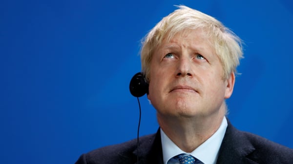 Prime Minister Boris Johnson looks on during a news conference with German Chancellor Angela Merkel