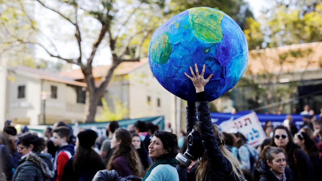 Protester wearing a gas mask and holding a globe takes part in a demonstration against Israels offshore Leviathan natural gas field due to environmental concerns