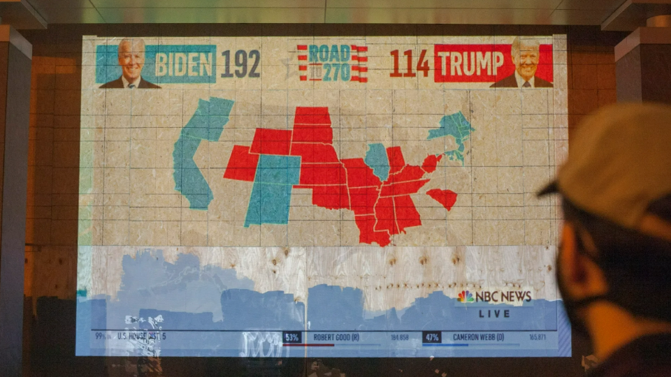 Protesters and residents of Washington D.C. watch as election results come in on projectors by the White House on November 3, 2020