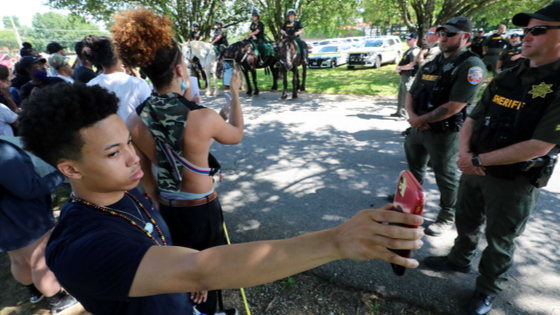 Protesters with smartphone filming.