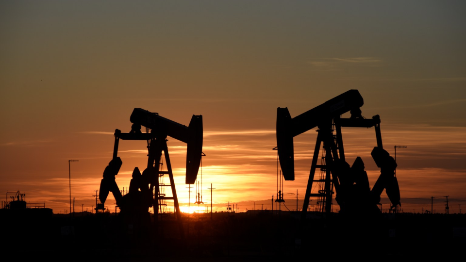 Pump jacks operate at sunset in an oil field in Midland, Texas.