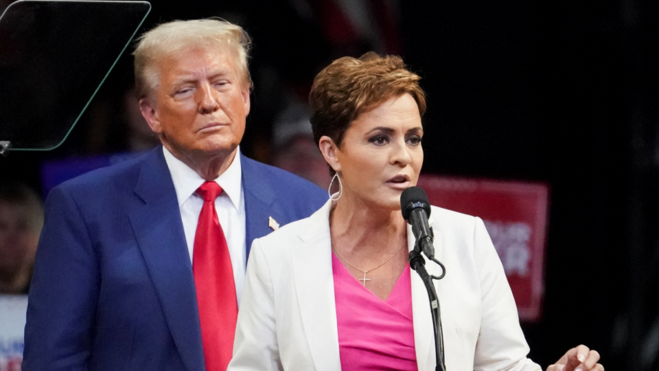 Republican presidential nominee and former U.S. President Donald Trump looks on as nominee for U.S. Senate in Arizona Kari Lake speaks during a campaign rally