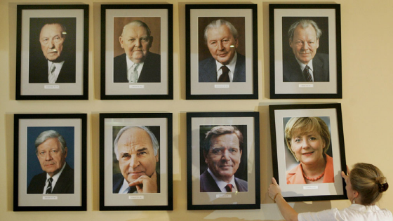 Restaurant manager Angelika Meixner places a portrait of new German Chancellor Angela Merkel beside pictures of her predecessors