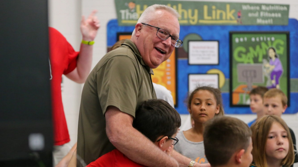 Rob Skaggs, Mintonye Elementary School principal, hugs his students