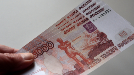 Russian banknotes of 5000 rubles seen displayed.