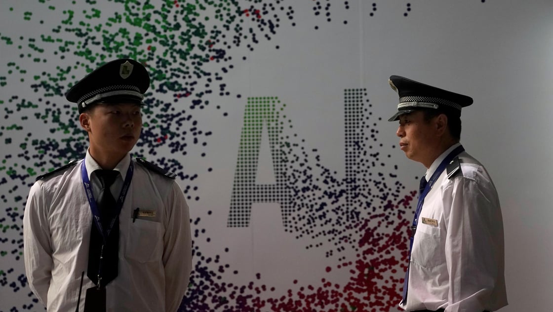 Security officers keep watch in front of an AI (Artificial Intelligence) sign at the annual Huawei Connect event in Shanghai