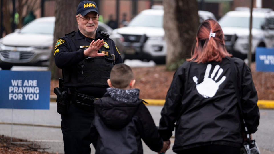 Sgt. Jamie Huling of the Newport News Police Department greets students as they return to Richneck Elementary in Newport News, Virginia.