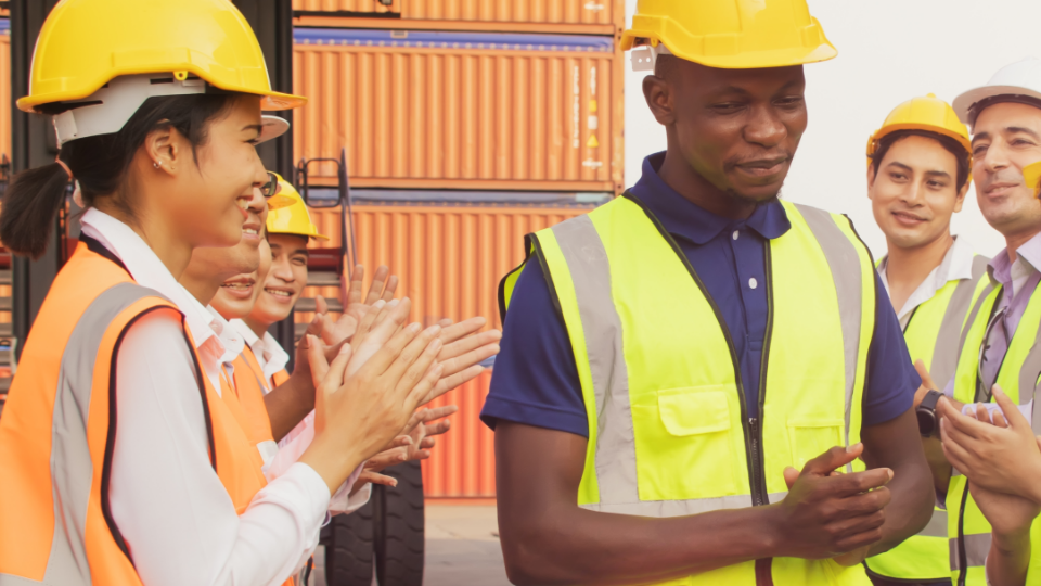 Shipping dock worker applauded by his colleagues.