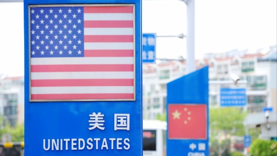 Signboards showing the flags of the United States and China are seen on a street in Qingdao