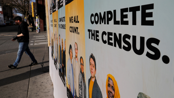 Signs advertising the 2020 U.S. Census cover a closed and boarded up business