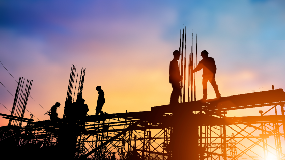 Silhouette of standing construction crew on worksite at sunrise