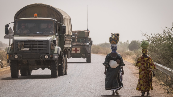 Soldiers drive by walking Mali residents