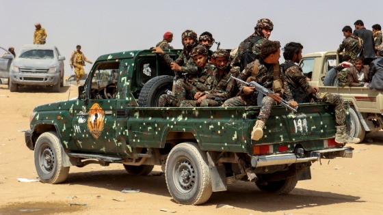 Soldiers ride on the back of a patrol truck during the burial of Brigadier General Abdul-Ghani Shaalan