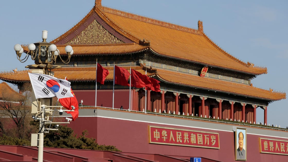 South Korean and Chinese flags flutter next to Tiananmen Gate