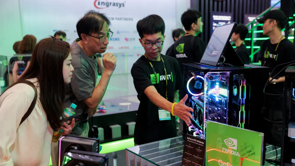 Staff introduce NVIDIA GeForce series equipment on display at Computex in Taipei, Taiwan