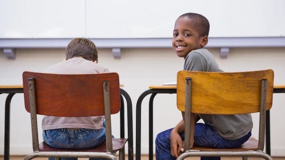 Student looks back while sitting with another student.