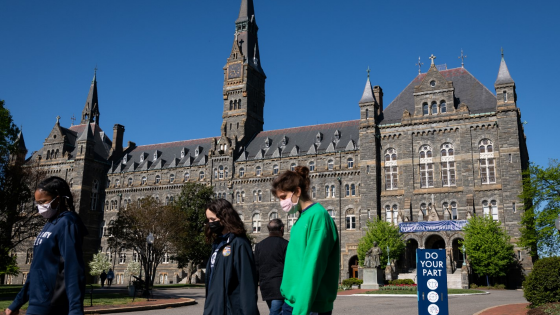 Students and pedestrians walk near Healy Hall at Georgetown University