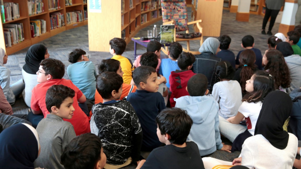 Students at Miller Elementary School sit and wait in the library for a visit from Kamala Harris in Dearborn