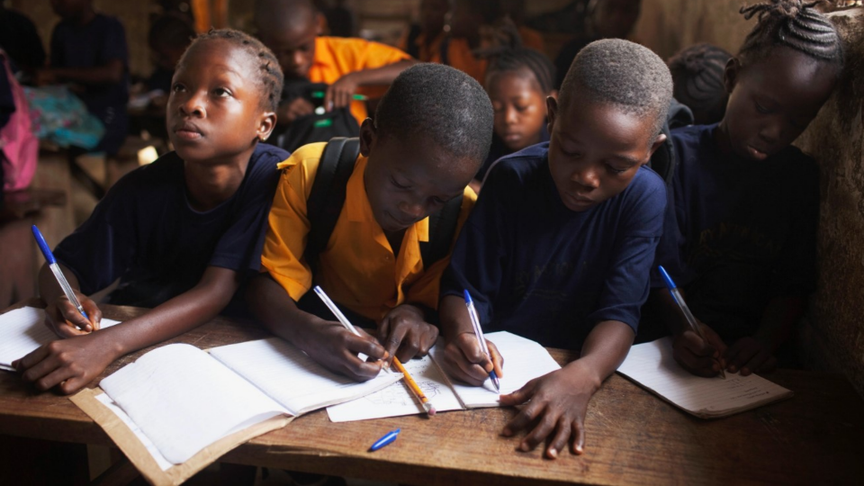 Students share a desk during a mathematics class at the Every Nation Academy in Makeni, Sierra Leone