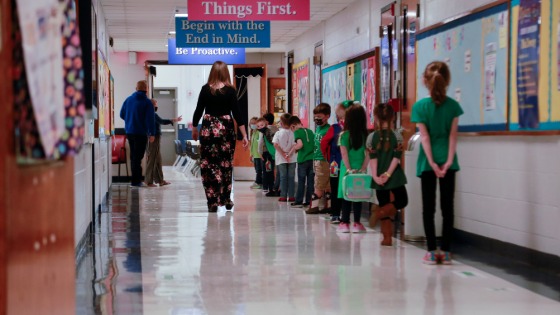 Students social distance while standing in line