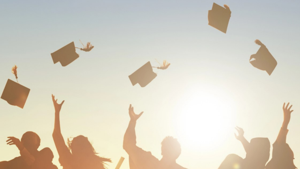 Students throwing their graduation caps into the air