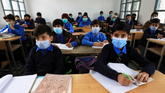 Students wear protective masks as they attend class