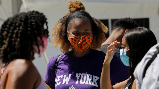 Students wear protective masks as they wait in line at a testing site for the coronavirus