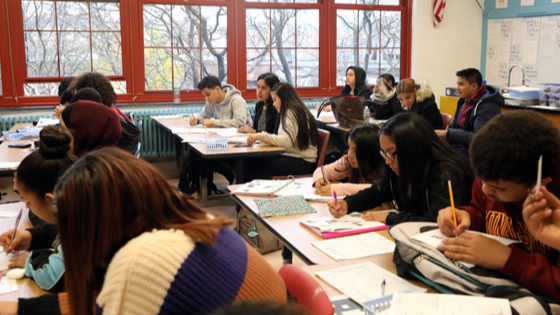 Students work in a classroom.