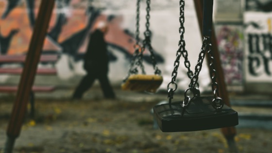 Swing set in front of a wall covered with graffiti