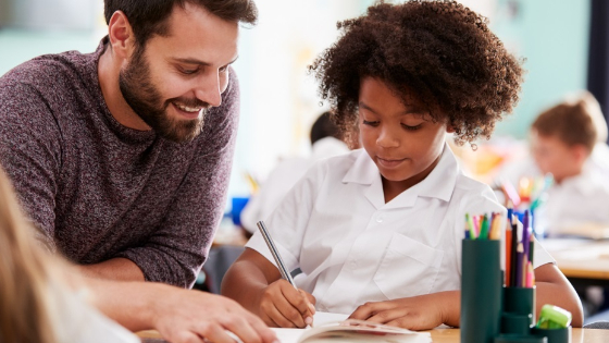 Teacher assists student with school work