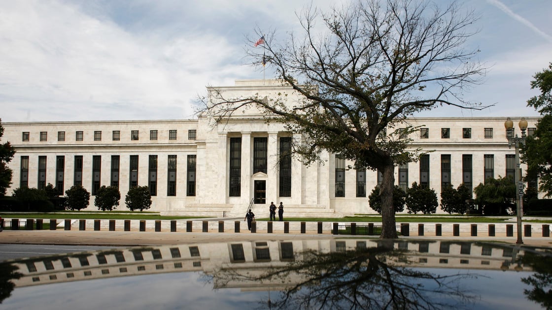 The Federal Reserve Building is reflected on a car in Washington.