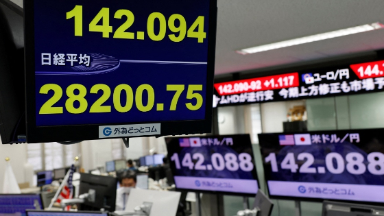 The Japanese yen exchange rate against the U.S. dollar and Nikkei share average are displayed on a monitor.