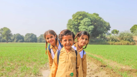 Three schoolchildren pose for a photo.