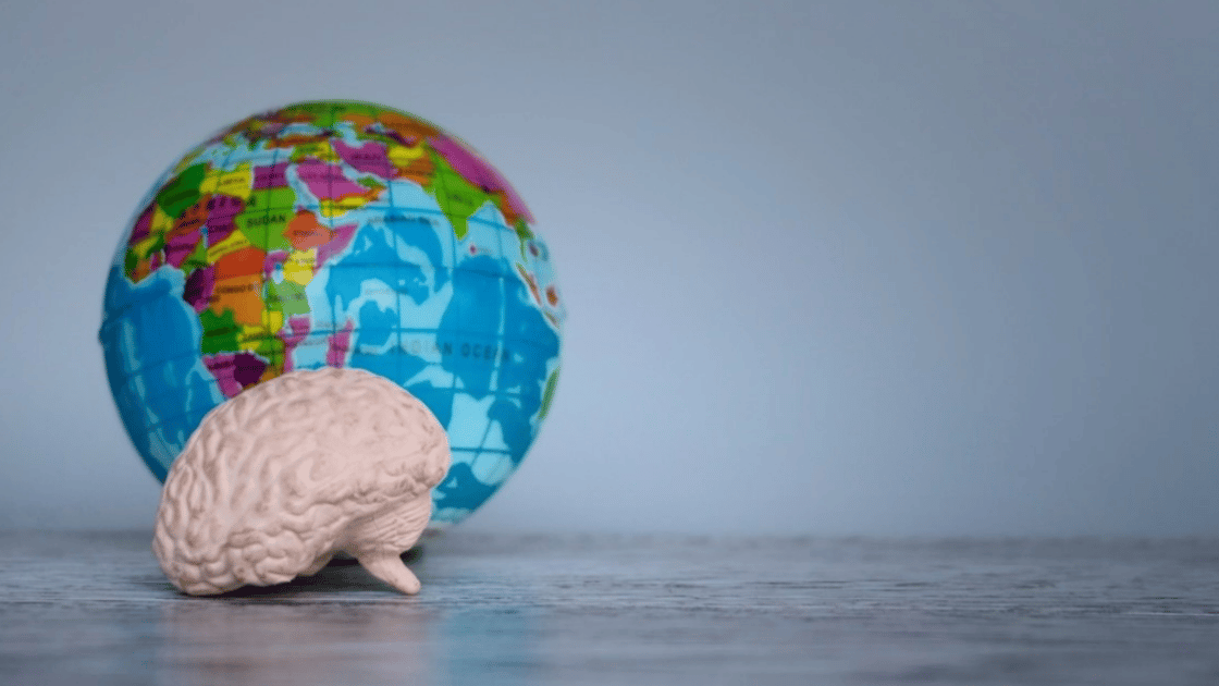 Toy globe with toy brain sitting in front of it