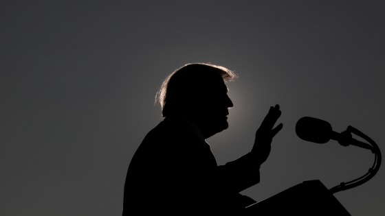 Trump is silhouetted as he delivers a speech while campaigning at Dayton International Airport