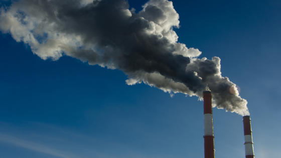 Two factory stacks emitting pollution into the air