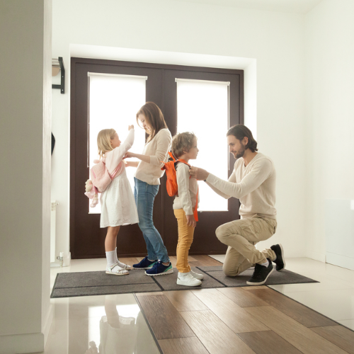 Two parents get their kids ready to go to school.
